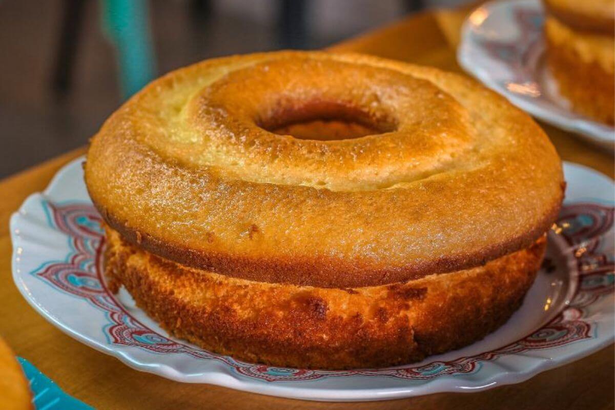 Bolo de fubá em cima de uma travessa redonda branca