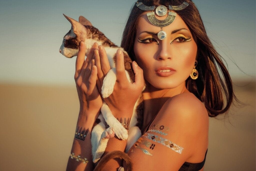 Mulher usando uma tiara egípcia segurando um gato