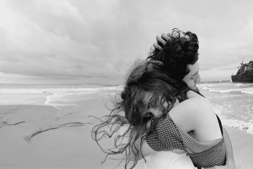 Imagem de casal abraçado em preto e branco na praia