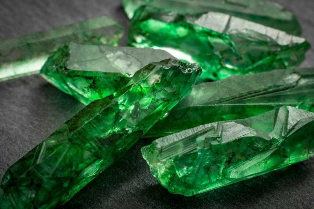 Imagem de pedras de esmeralda em cima de mesa preta