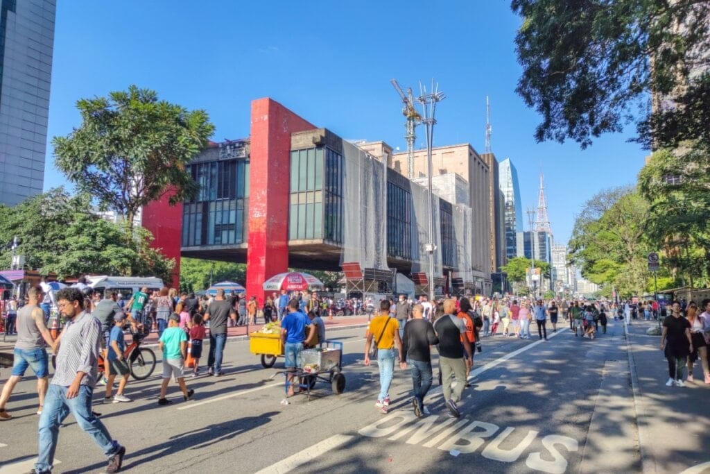 Vista do MASP na Paulista com a avenida fechada e pessoas passando na rua 