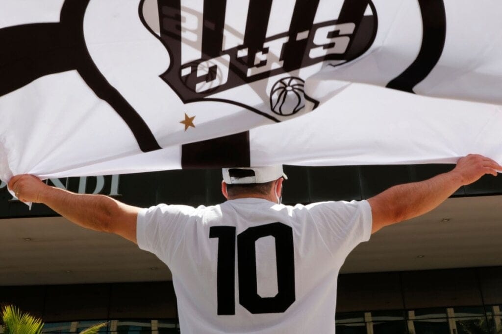 homem de costas, com camiseta branca com número 10 e bandeira do santos