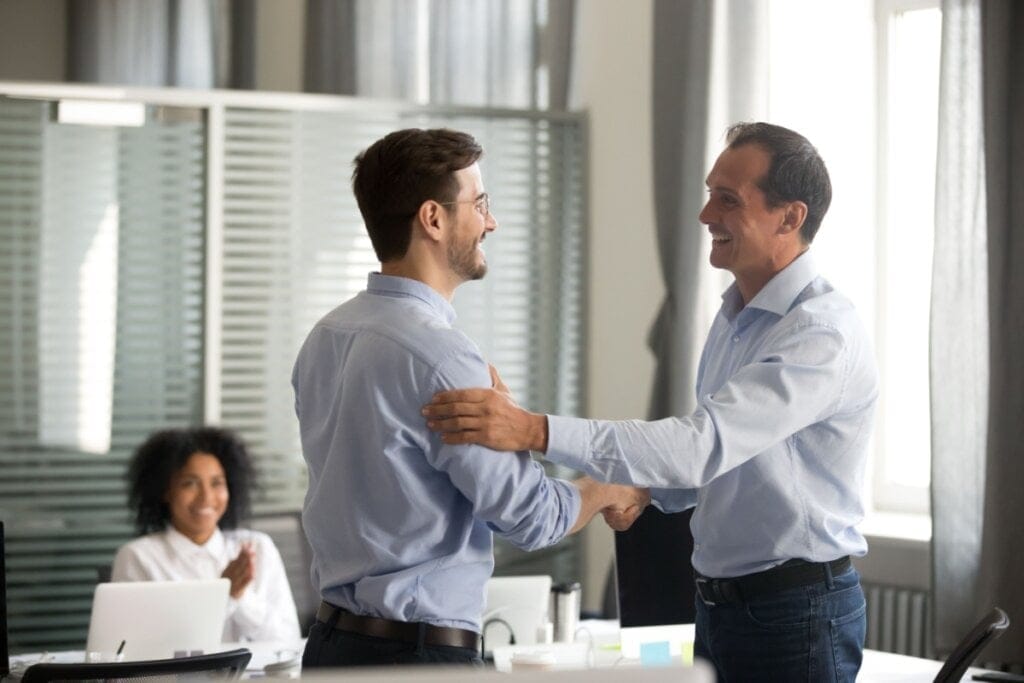 Homem sendo elogiado pelo chefe no trabalho 