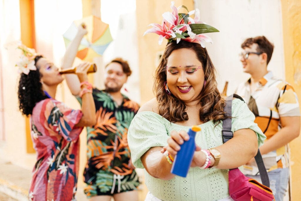 Mulher curtindo o Carnaval e passando protetor solar na pele