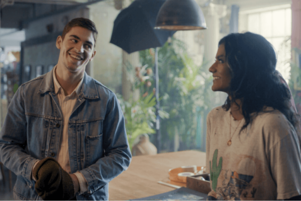 Jovem casal se encara sorridente em um ambiente iluminado por luz natural