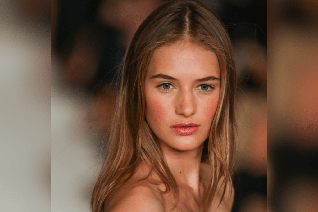 Mulher com blush aplicado nas maçãs do rosto e topo do nariz