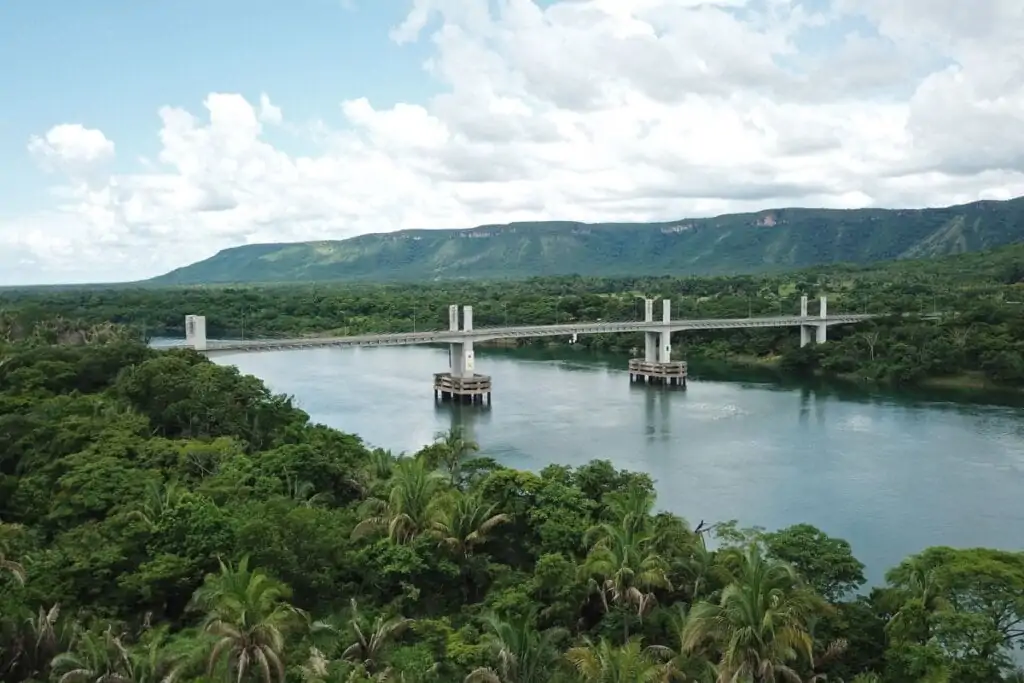Imagem aérea do Rio Tocantins com uma ponte e montanhas com árvore  