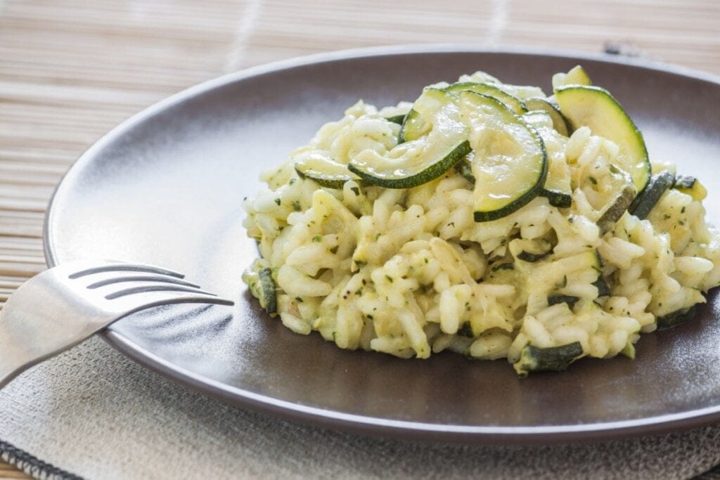 Prato marrom com risoto com abobrinha