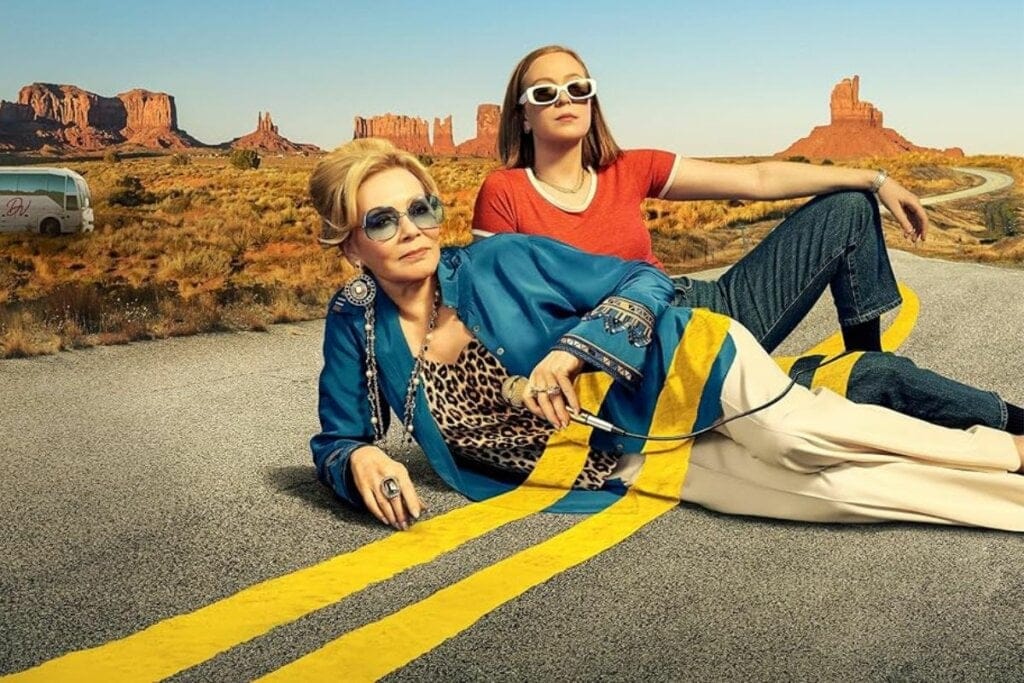 Duas mulheres deitadas em uma estrada na capa da série 'Hacks'