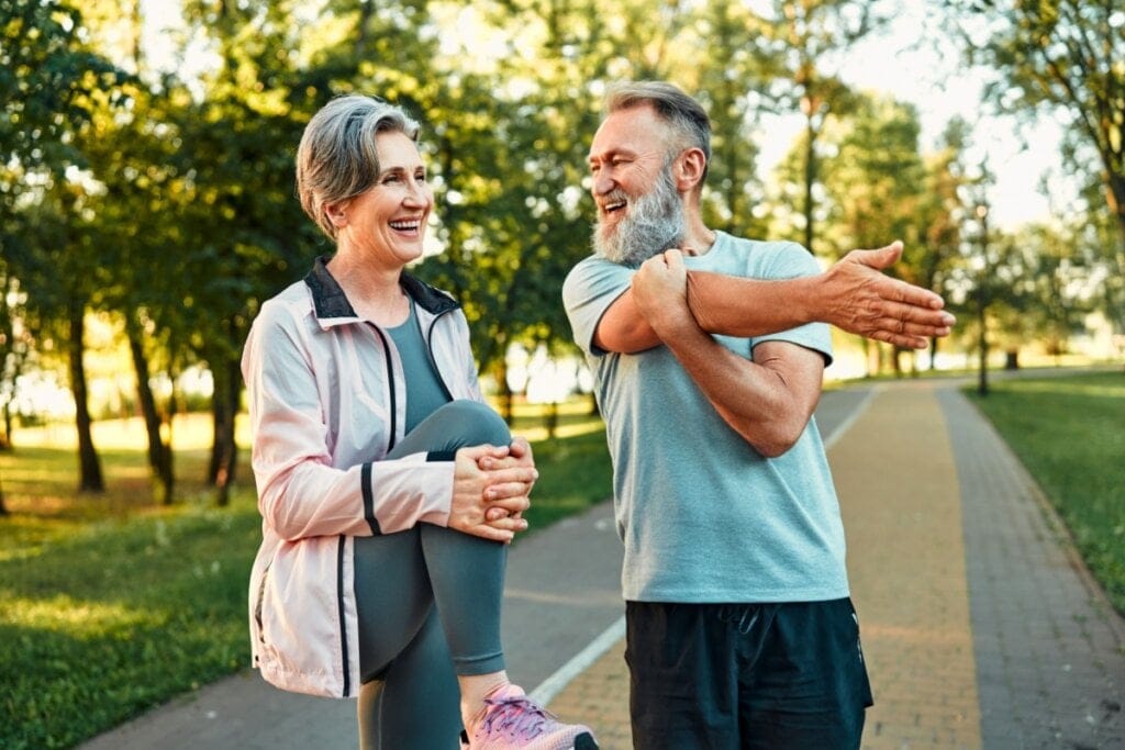 Mulher e homem em um parque alongando o corpo