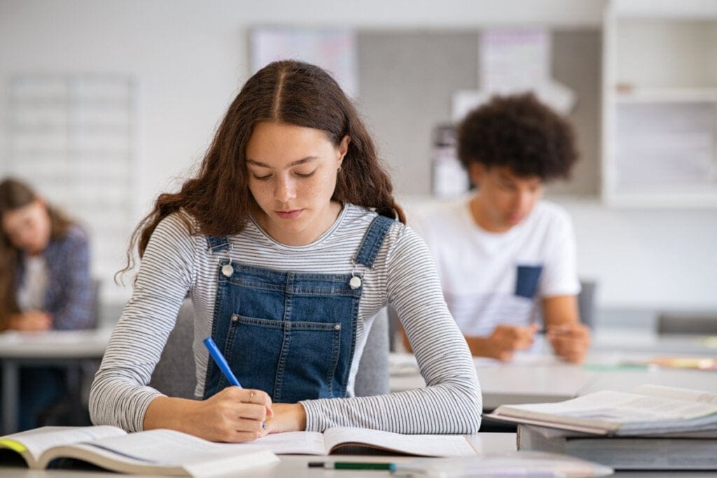 Estudante fazendo anotações do livro para seu estudo