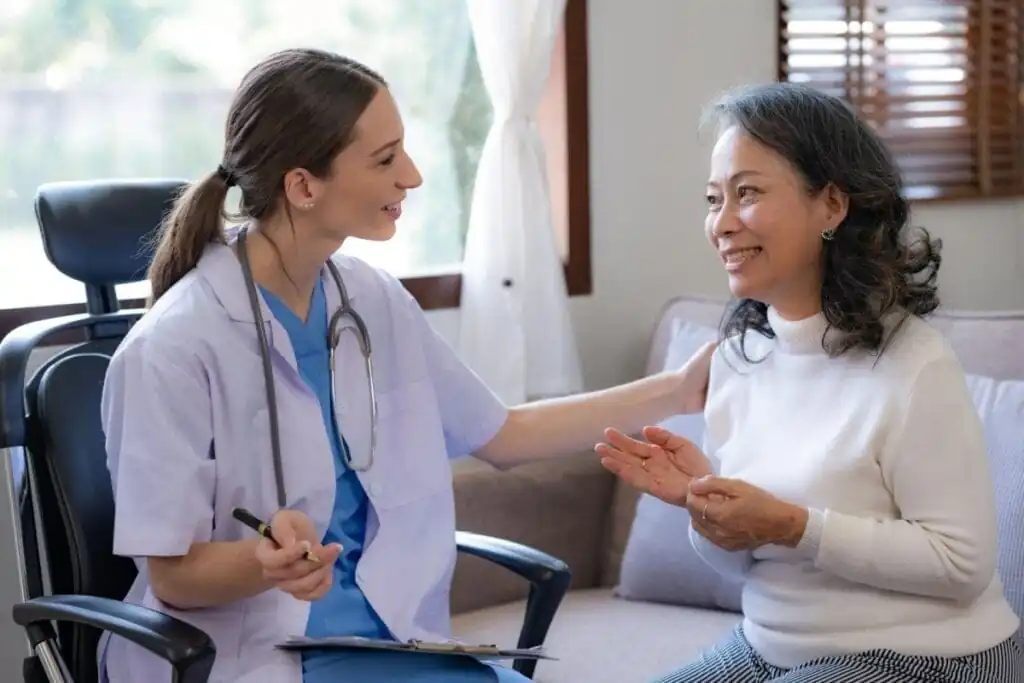 medica e paciente sentadas, se olhando e sorrindo