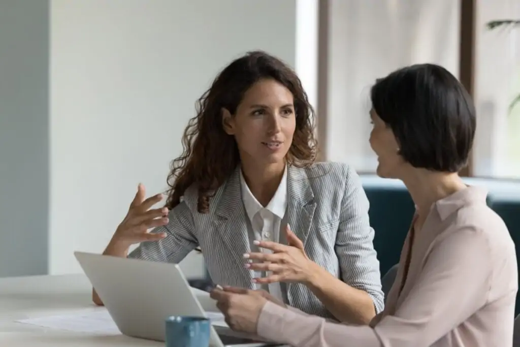 Mulher conversando com chefe em uma sala de reunião