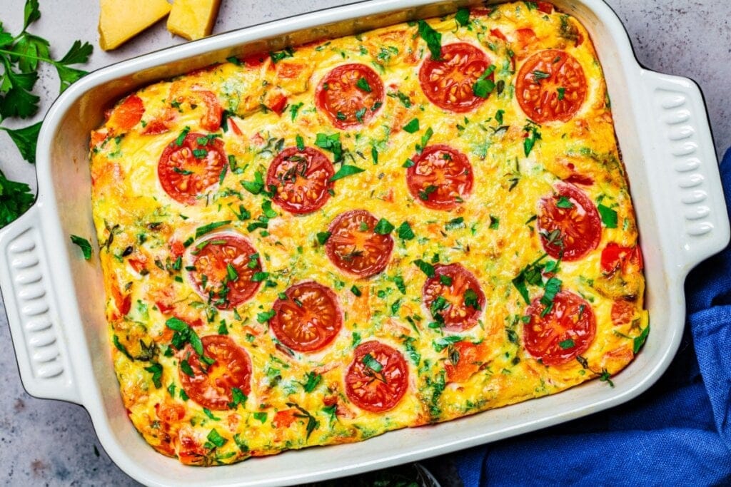 Omelete de forno com tomates-cerejas em uma travessa branca 