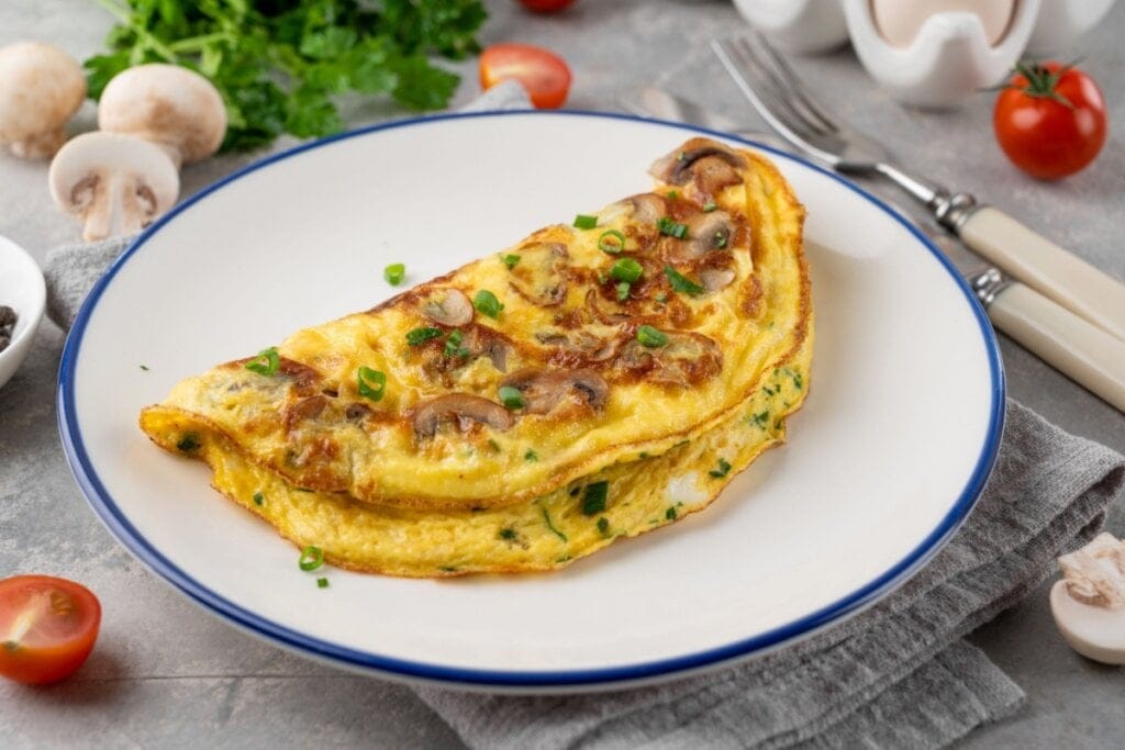 Omelete de cogumelo servida em prato de porcelana branco