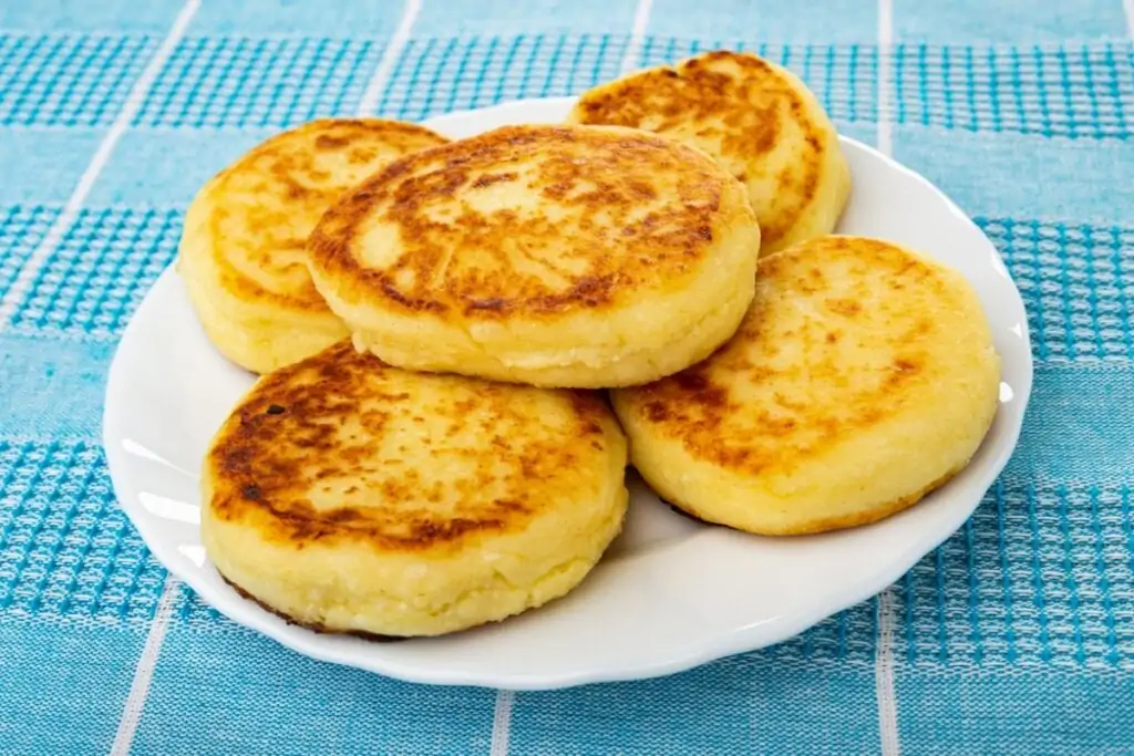 Cinco pães de frigideira recheados com queijo cottage em prato branco