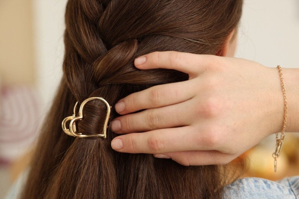 cabelo castanho liso com piranha dourada em formato de coração