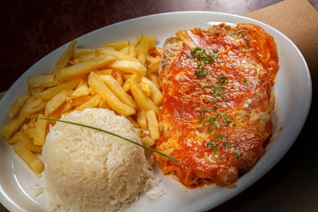 Prato branco com bife à parmegiana com batata-frita e arroz branco
