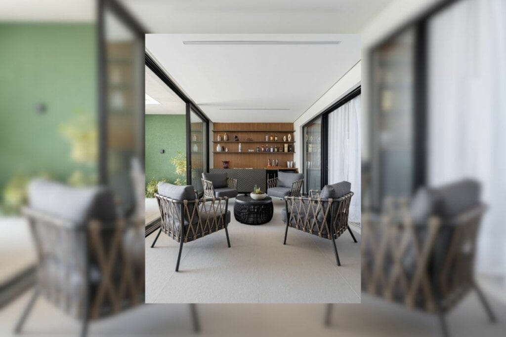 Sala de estar com móveis cinza e parede revestida com madeira ao fundo 