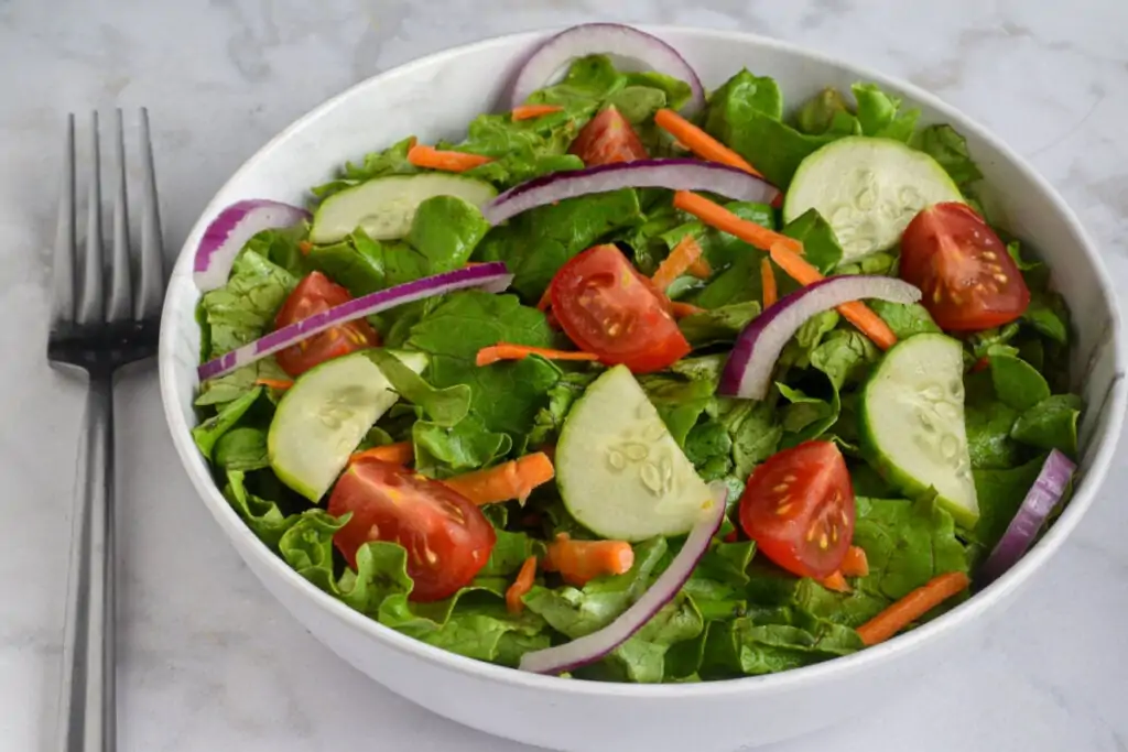 Pote branco com alface, tomate, pepino, cebola e cenoura