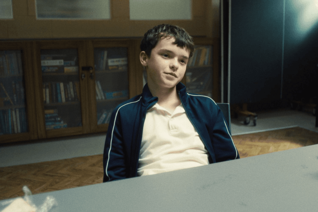 Imagem de um adolescente sentado e com uma expressão de deboche